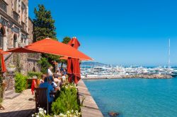 Un ristorante di Mandelieu-la-Napoule di fronte al porto con turisti seduti ai tavoli all'aperto (Francia) - © Juergen Wackenhut / Shutterstock.com