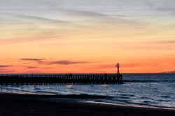 Un romantico tramonto sul molo di Courseulles-sur-Mer, Normandia, Francia. Questa graziosa località balneare del Calvados si affaccia sulla Manica.
