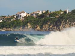 Un surfer fra le onde di Playa Zicatela a Puerto Escondido, Messico. Molto frastagliata e con piccole baie e insenature, la costa di Puerto Escondido è nota in tutto il mondo per gli ...