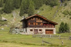 Un tipico chalet in pietra e legno nel villaggio di Arolla, Svizzera, immerso nella natura - © Rob Crandall / Shutterstock.com