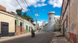 Un uomo in motorino lungo una via della città di Tegucigalpa, Honduras. Gli anni della colonizzazione spagnola sono tutt'ora visibili negli edifici - © Kanokratnok / Shutterstock.com ...