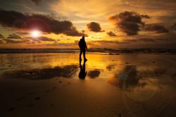 Un uomo sulla spiaggia con un suggestivo tramonto a Esposende, Portogallo.

