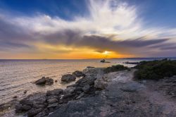 Una barca naufragata davanti alla costa di Calasetta (Sardegna) con il tramonto.



