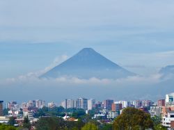 Una bella veduta del vulcano Fuego avvolto dalla nebbia a Città del Guatemala, Guatemala. E' noto per la sua attività stromboliana che alterna cioè fasi di grandi esplosioni ...