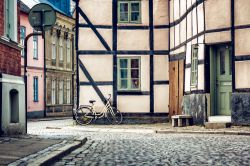 Una casa a graticcio nel centro di Lund, Svezia, con una bicicletta parcheggiata accanto a una finestra.

