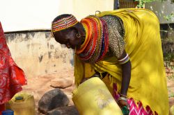 Una donna in abiti tradizionali raccoglie acqua in un bidone di plastica a Marsabit, Kenya - © Adriana Mahdalova / Shutterstock.com