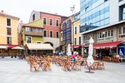 Una piazza di Gijon, Spagna, con sedie e tavoli di bar e ristoranti per pranzare all'aperto - © Kevin Hellon / Shutterstock.com