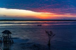 Una pittoresca alba dall'isola di Lamu, Kenya: le luci del mattino si riflettono sull'acqua. Sullo sfondo, Manda Island separata da Lamu da uno stretto braccio di mare.

