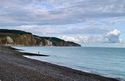 Una spiaggia a Pourville-sur-Mer, Alta Normandia, Francia. Questo antico villaggio di pescatori è divenuto una popolare località francese. Circondato da scogliere, il borgo di ...