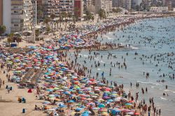 Una spiaggia affollata in estate a Calpe, Spagna. La città si affaccia sul Mar Mediterraneo.

