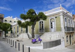 Una strada del centro di Sesimbra (Portogallo) con un edificio storico in stile moresco e una Vespa - foto © jorisvo / Shutterstock.com