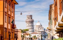 Una strada del centro storico di Pisa e in prospettiva il campanile e il Duomo in Piazza dei Miracoli