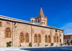 Una strada innevata con una vecchia chiesa a Cuneo, Piemonte.



