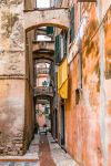 Una strada stretta nel centro medievale di Albenga, Liguria. Da notare la pavimentazione ciottolata tipica di queste località liguri.



