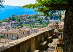 Una turista scatta una fotografia panoramica di Altomonte e del paesaggio limitrofo da piazza Tomaso Campanella, provincia di Cosenza, Calabria - © EugeniaSt / Shutterstock.com