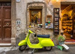 Una vespa color giallo limone in una stradina del centro storico di Pitigliano, Toscana - © 54115341 / Shutterstock.com