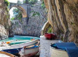 Uno scorcio del Fiordo di Furore, provincia di Salerno, con barche da pesca colorate sulla spiaggia (Campania). Sullo sfondo, il ponte.

