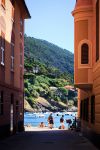 Uno scorcio del mare con i bagnanti in spiaggia visto da un carruggio di Sestri Levante, Liguria - © SimoneN / Shutterstock.com