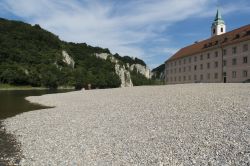 Uno scorcio del monastero di Weltenburg lungo le gole del Danubio, Germania. A causa della sua esposizione diretta sul fiume (in foto alcuni bagnanti sulla spiaggia di ghiaia), l'abbazia ...