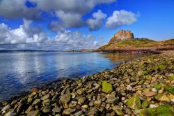 Uno scorcio della costa rocciosa di Holy Island, Northumberland (Inghilterra). Sullo sfondo, il maniero del XVI° secolo.
