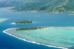 Veduta aerea dell'atollo dell'isola di Huahine, Polinesia Francese. Come gran parte delle isole polinesiane, anche Huahine è circondata dalla barriera corallina.

