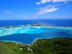 Veduta aerea di Bora Bora, Isole de la Société, Polinesia Francese. Quante sfumaure di azzurro esistono? Dal blu intenso al turchese brillante, passando per il celeste con riflessi ...
