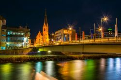 Veduta by night di un ponte sul fiume Drava con la chiesa di San Nicola a Villach, Austria - © trabantos / Shutterstock.com