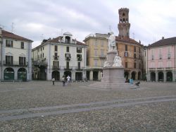 Veduta della centralissima piazza Cavour con la Torre dell'Angelo a Vercelli, Piemonte. A forma trapezoidale con i due lati maggiori, a sud e nord, che formano una leggera curva per rendere ...
