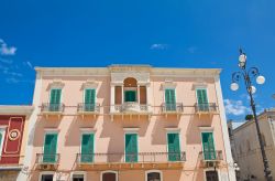 Veduta della facciata del Palazzo Latorre a Fasano, Puglia. Il rosa antico scelto per l'esterno è impreziosito dal verde degli scuri.

