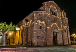 Veduta notturna della chiesa di San Simplicio a Olbia, Sardegna. L'edificio sacro presenta una facciata tripartita da due lesene e arricchita da una trifora incassata.
