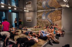Visitatori si riposano su una ripoduzione in lana del Santa Cruz River alla National Gallery of Victoria Triennial di Melbourne, Australia. Si tratta di un'opera realizzata dall'artista ...