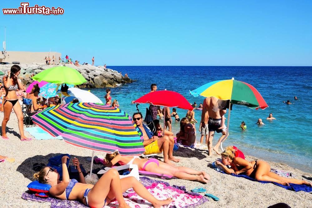 Immagine Spiaggia affollata a Bergeggi, Savona, Liguria. Il borgo ligure, abbarbicato a 1100 metri di quota e immerso in un paesaggio mozzafiato, è una delle località piu frequentate dal turismo durante i mesi estivi © maudanros / Shutterstock.com
