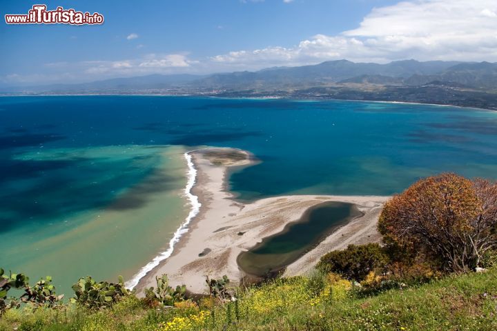 Immagine Fotografia panoramica della spiaggia selvaggia di Capo Tindari (Sicilia) - L'immagine mostra in tutta la sua generosità una vista che regala l'idea paradisiaca della spiaggia di Capo Tindari. Non ordinata, non lineare ma al contrario somigliante ad un collage che non è mai stato domato dalla natura, questa fusione di blu data dal cielo e dal mare, con le sue mille sfumature di ceruleo, non sa rimanere statica. In movimento continuo per il soffiare dei venti che crea nel verde circostante una brezza marina piacevole sia da sentire che da odorare, qui a Capo Tindari arrivano tutti i turisti che desiderano scattare una bellissima foto panoramica da portarsi a casa oltreché nel cuore - © Oskar Orsag / Shutterstock.com