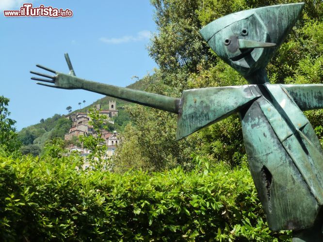 Immagine Una delle numerose statue di Pinocchio presso il parco a lui dedicato, e sullo sfondo il piccolo borgo di Collodi, nella campagna toscana in provincia di Pistoia.