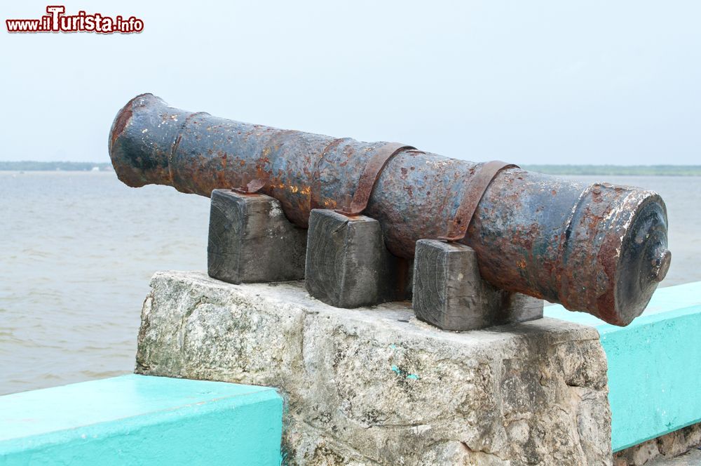 Immagine Un vecchio cannone arrugginito su un blocco di cemento lungo la baia di Chetumal, Messico. Sullo sfondo, la costa del Belize.