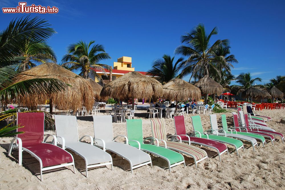 Immagine Una fila di lettini colorati nella spiaggia di un resort a Mahahual, Messico.