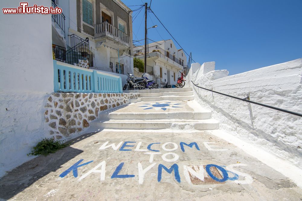 Immagine Una stradina con gradini in pietra e la scritta di benvenuto sull'isola di Kalymnos, Grecia.