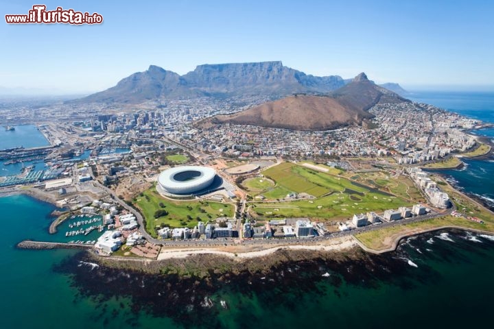 Immagine Vista aerea di Cape Town, Sudafrica - Tra tutto quello che spicca in questa immagine, come sempre l'educazione visiva ci pone di fronte a degli zoom dell'animo. Spiccano infatti due elementi in particolare: lo stadio (chiamato anche Green Point come il nome precedente) e Table Mountain. Questo gioco di natura e architettura crea, dall'alto, una scenografia sorprendente, degno dei migliori pittori.