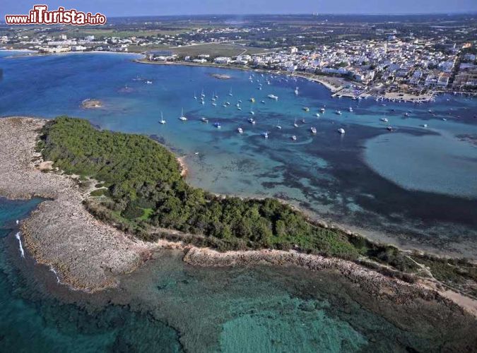 Immagine Vista aerea di Porto Cesareo: in primo piano l'isola dei Conigli, a desta il borgo marinaro ed il porto a sinistra la spiaggia del Conchiglia azzurra, lo Scalo di Furno e la Spiaggia delle Dune.