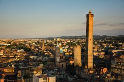 Tramonto sul centro di Bologna: le due torri pendenti, l'Asinelli e la Garisenda, in primo piano, ricevono gli ultimi raggi di luce - © starmaro / Shutterstock.com 