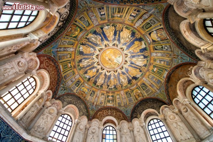 Immagine Interno della cupola del monumento UNESCO di Ravenna: si noti il mosaico suddiviso in un medaglione centrale e due zone concentriche con Apostoli e una raffigurazione della città celeste - © pisaphotography / Shutterstock.com