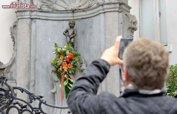 Immagine Turista scatta una fotografia ricordo del Manneken Pis, il simbolo di Bruxelles - © skyfish / Shutterstock.com