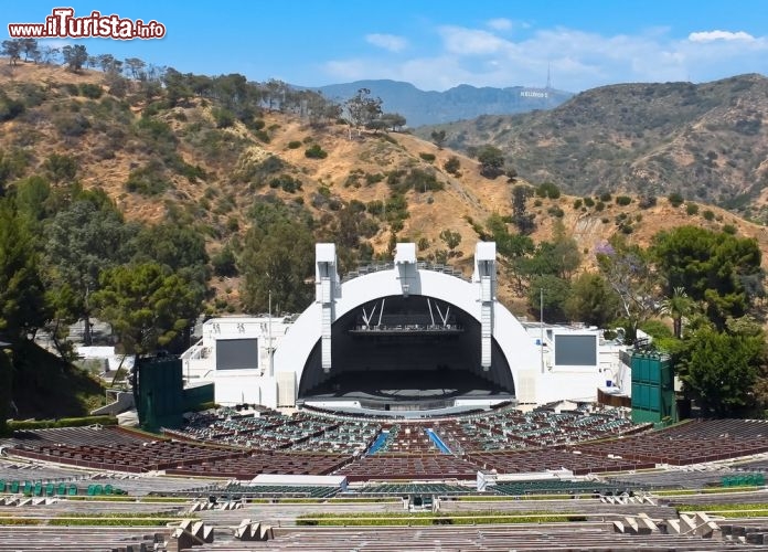 Immagine L'anfiteatro naturale da oltre 17.300 posti a sedere dell'Hollywood Bowl,  a Los Angeles. Sullo sfondo la scritta dell'Hollywood Sign, il simbolo del quartiere di L.A. - © Palette7 / Shutterstock.com