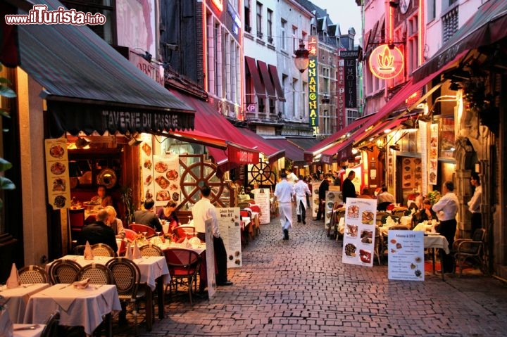Immagine Dove mangiare a Bruxelles? A fianco della Grand Place, la gigantesca piazza centrale, troviamo le stradine dell'Ilot Sacre, in cui potete avere una vasta scelta tra ristoranti, brasserie e taverne tipiche dove pasteggiare, gustando la famosa birra belga. Rue des Bouchers, fotografata qui verso sera, è una delle strade più vitali di tutto il centro storico della capitale del Belgio  - © Tupungato / Shutterstock.com