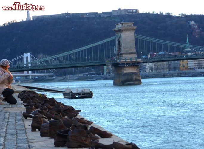 Immagine La nostra Monica presso il Monumento delle scarpe in riva al Danubio: ricorda un eccidio di Ebrei avvenuto durante la seconda Guerra Mondiale. Sullo sfondo il Ponte delle Catene di Budapest - © Monica Mereu