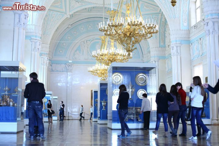 Immagine Turisti all'interno della Sala di Alessandro. Questa stanza bianco-celeste dell'Ermitage di San Pietroburgo venne creata dall'artista Briullov che rimediò all'incendio del 1837 che l'aveva danneggiata - © Pavel L Photo and Video / Shutterstock.com