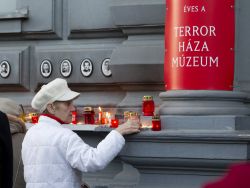 Una visitatrice accende una candela alla Terror Haza. Oltre che un museo nteressante dal punto di vista storico, la Casa del Terrore di Budapest è meta di "pellegrinaggi" di ...