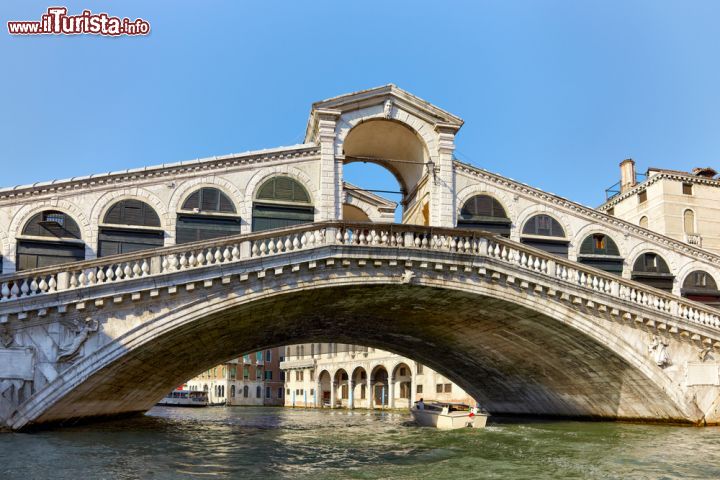 Immagine L'inconfondibile sagoma del ponte più antico sul Canal Grande: opera di Antonio Ponte, il Rialto è un vero simbolo di Venezia. E' stata la prima struttura fissa che attraversava il Canal Grande, e venne eretto nella sua prima versione quasi 950 anni fa, ma il Ponte di Rialto è stato ricostruito più volte a seguito di numerosi crolli - © Serg Zastavkin / Shutterstock.com