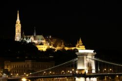 Fotografia notturna della fortezza Halaszbastya a Budapest. Si noti a fianco la Chiesa di Mattia e in primo piano il Ponte delle Catene - © risteski goce / Shutterstock.com
