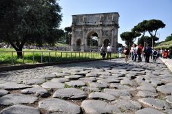 Un'antica pavimentazione romana e sullo sfondo il grande Arco di Costantino: siamo a fianoc dei Fori Imperiali di Roma